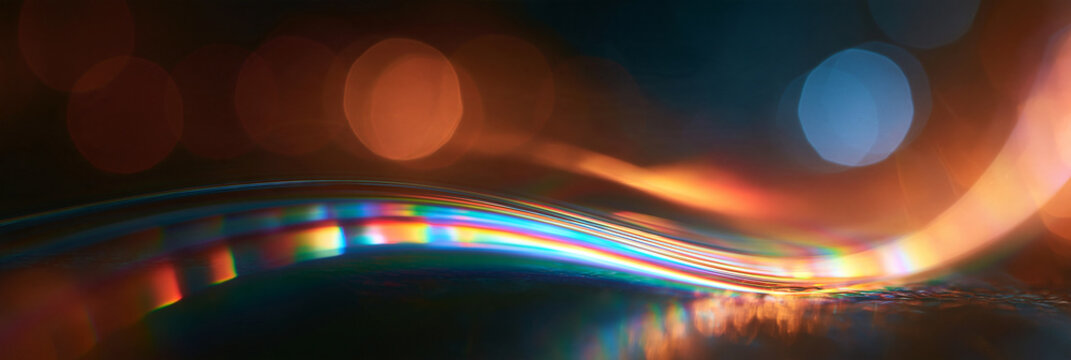 Geschwungene Lichtlinie mit Regenbogenreflexion und Bokeh in Orange und Blau