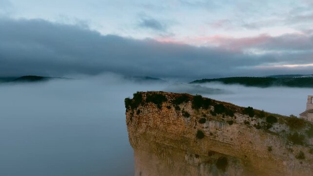 Peque&ntilde;a iglesia rom&aacute;nica de piedra construida sobre una colina rocosa con forma de barco al amanecer, con niebla en el Valle de Losa, Arquitectura medieval antigua, templo hist&oacute;rico rural, Pantale&oacute;n.