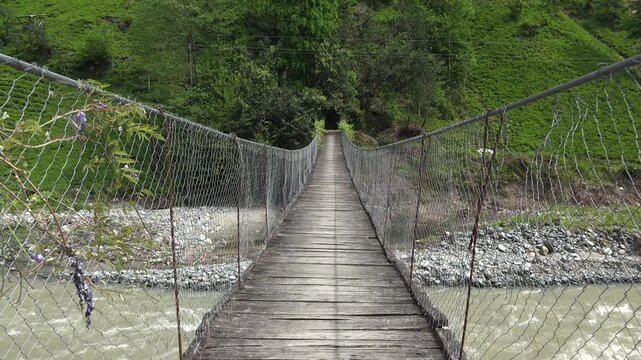 Rize Turkey wooden suspension bridge crosses a narrow river valley above fast water.