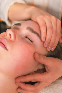 Woman receiving a gentle head massage at spa, illustrating neurowellness, nervous system regulation, stress relief, therapeutic touch, relaxation and holistic wellbeing.