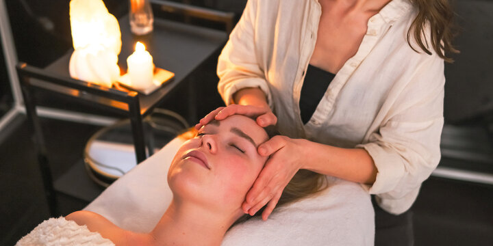Woman receiving a gentle head massage at spa, illustrating neurowellness, nervous system regulation, stress relief, therapeutic touch, relaxation and holistic wellbeing.