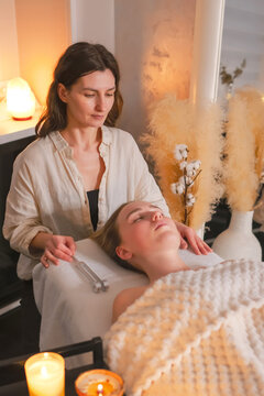 Woman receiving tuning fork sound therapy during a holistic wellness session, representing neurowellness, nervous system regulation, sensory relaxation and restorative self care.