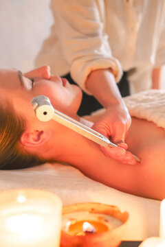 Woman receiving tuning fork sound therapy during a holistic wellness session, representing neurowellness, nervous system regulation, sensory relaxation and restorative self care.