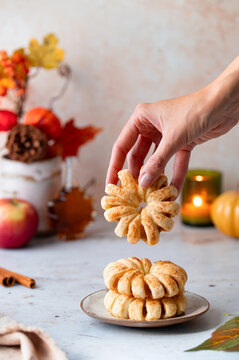 Female hand picking baked apple pastry, fall treat