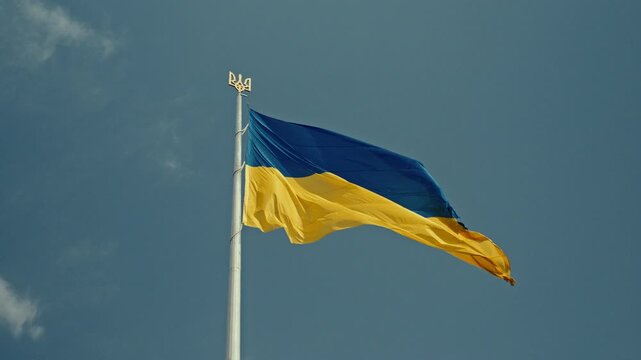 Ukrainian flag with a golden trident on the flagpole