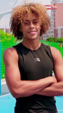 vertical Confident young basketball player posing on an outdoor court