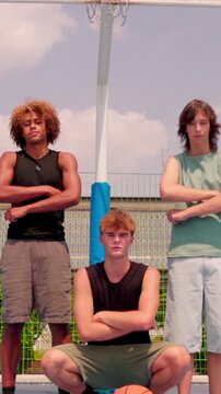 vertical Multicultural friends posing on a basketball court