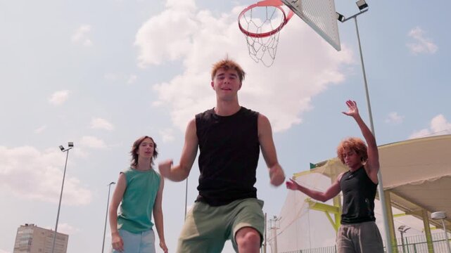 Multicultural friends playing basketball and celebrating a score