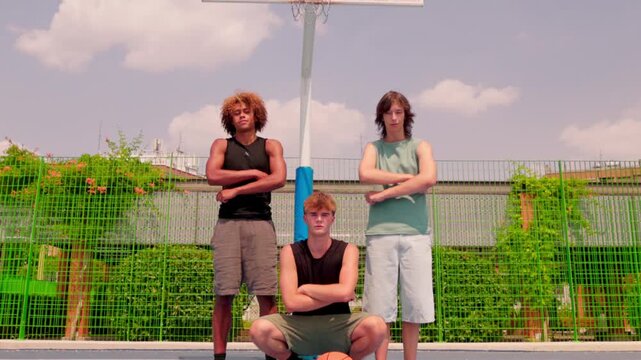 Multicultural friends posing confidently on an outdoor basketball court