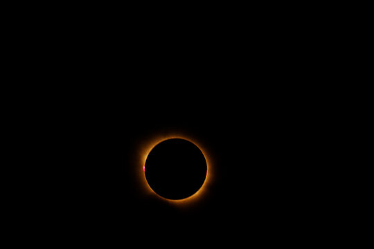 Magnificent total solar phase during the August 12, 2026 eclipse in Spain, highlighting the glowing corona and visible red solar prominences around the dark lunar disc.   
