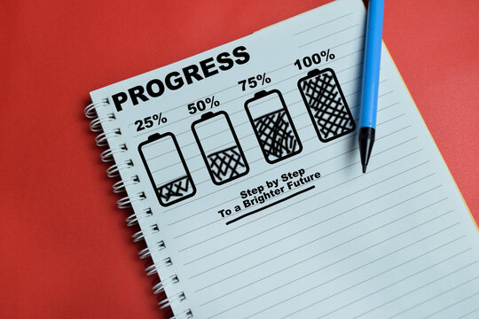 Concept of progress loading battery icon step by step write on book isolated on table. For target, success and growth
