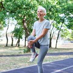 Obraz premium Portrait of a senior mature woman exercising, stretching, warming up, running and jogging outdoors in the park