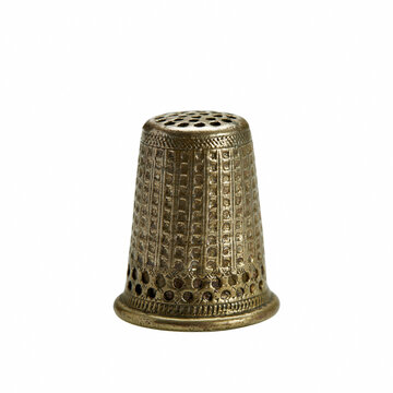 Vintage bronze thimble with intricate embossed pattern isolated on white background representing traditional sewing craftsmanship, handicraft tools, tailoring history, and needlework.