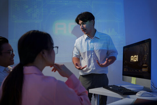 Group of diverse colleagues listening to a speaker presenting about Artificial General Intelligence - AGI - in a modern office meeting