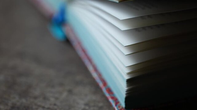 Open book pages focusing slowly with text and a blue bookmark in a library. Macro perspective for studying and knowledge