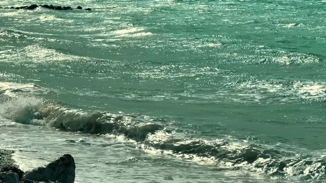 Sea Waves Breaking On Pebble Shore Line With White Foam Spray. Sea Coast. Tide 