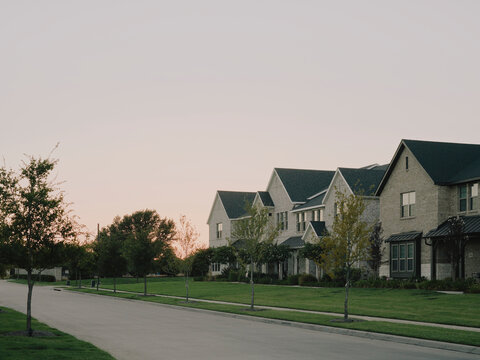 Quiet suburban residential street with brick houses at sunset