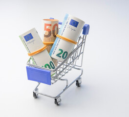 Rolls of euro banknotes in a miniature shopping cart concept of inflation and consumer spending  © Леся Петренко
