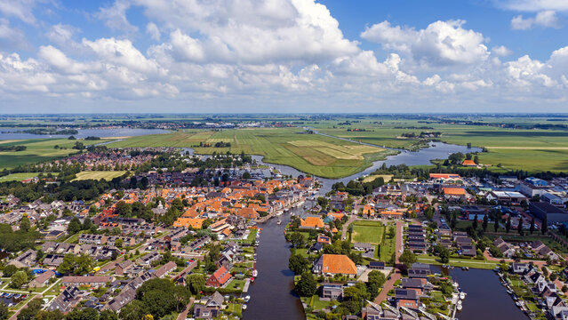 Aerial view of a historic waterside village with boats and windmill in Europe