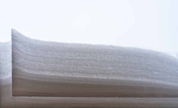 View of a cross-section of a snowbank showing layered accumulation and texture in Vilnius, Vilnius County, Lithuania.