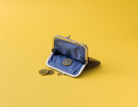 Open Coin Purse with Last Euro Coins on Yellow Background