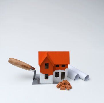Model House on Mason Trowel with Construction Materials