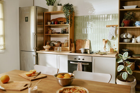 Kitchen interior featuring cooking ingredients and fresh food prepared on table. Suitable for culinary blogs, healthy nutrition campaigns, and household lifestyle advertising