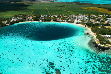 Top view of the Blue Bay lagoon of Mauritius. A boat floats on a turquoise lagoon © Alex