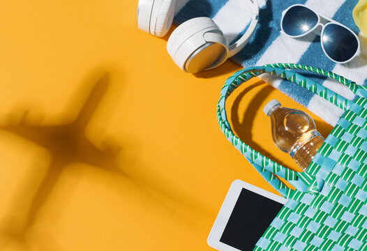 Airplane Shadow and Summer Beach Essentials on Yellow Background