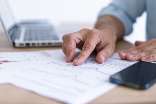 Businessman analyzing financial graph report and marketing data on clipboard