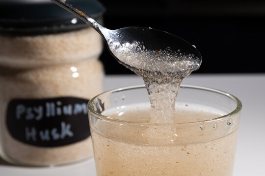 Pouring soaked psyllium gel into a glass for a high fiber supplement