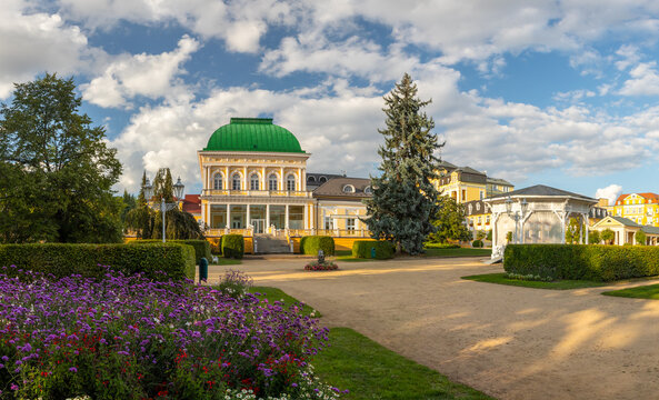Historic Social Hall building with green dome and park gardens with flowers on a sunny summer day, Frantiskovy Lazne, Czech Republic