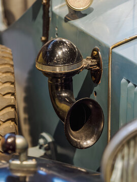 An old black horn on the side of a vintage car detail.