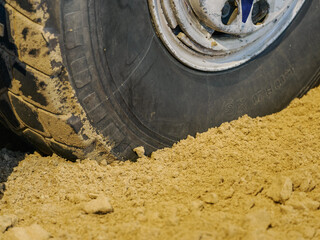 Detail of a tire slightly sunken into the sand. © lapis2380