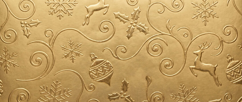 Embossed gold Christmas wrapping paper texture. Shiny metallic holiday background with reindeer and snowflakes