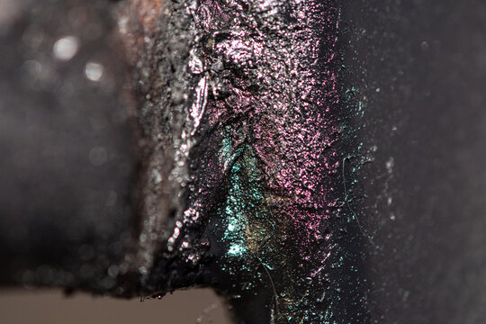 Macro close up of iridescent metallic welding seam on dark steel