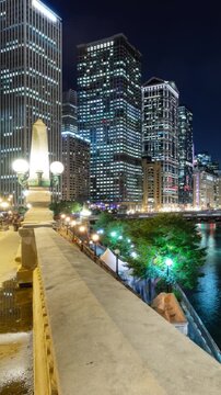 Beautiful time lapse of the many high-rise buildings along the Chicago River at night. Vertical video.