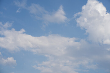 Fototapeta premium Blue sky with soft white clouds and open copy space in center close up