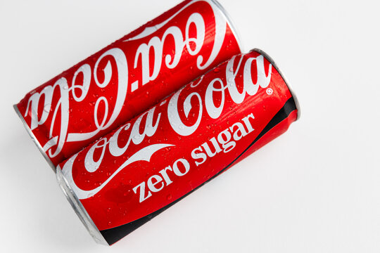 LVIV, UKRAINE - SEPTEMBER 23, 2026: Two red aluminum cans of Coca-Cola and Coca-Cola Zero Sugar soft drinks with water drops on white background