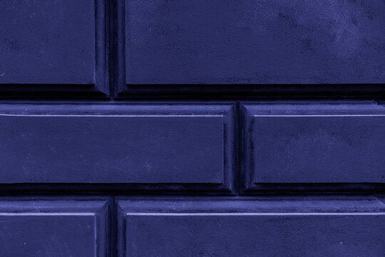Dark blue rusticated wall texture with rectangular blocks and deep grooves as abstract background