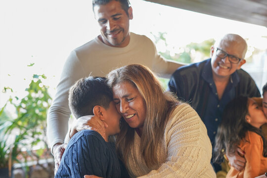 Happy latin american grandmother having tender moment with grandson at house patio during family dinner - Multi generational people, love and bonding concept
