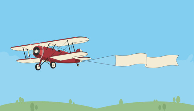 Red biplane flying over green hills against a blue sky pulling a long blank cream-colored banner for advertising messages.