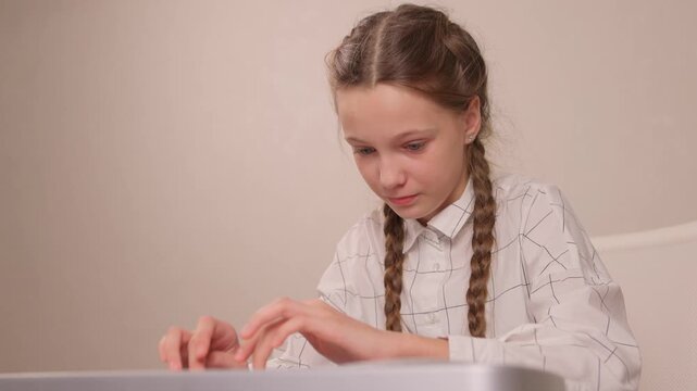 Young female musician rehearsing melodies on digital piano at home. Brightly lit scene of youthful girl honing musical skills on electronic keyboard in cozy environment