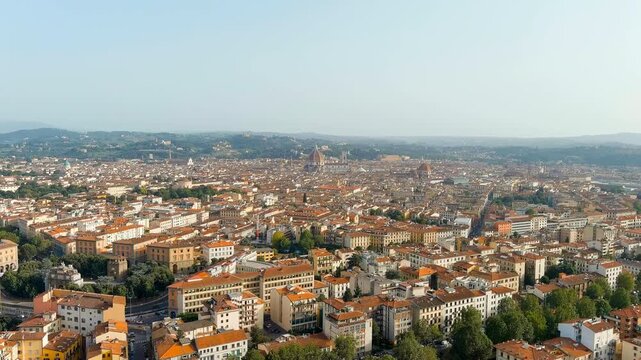Florence, Italy. Cathedral Santa Maria del Fiore, Brunelleschi's octagonal dome dominating the skyline, panoramic Drone footage over terracotta rooftops under hazy summer light. Drone footage