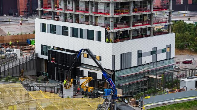 Helsinki, Finland - 25 August 2022: View of the ongoing high-rise construction project in the Kalasatama district with cranes and workers on site. Timelapse.
