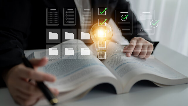 A business professional reviews important documents while utilizing a digital interface, symbolizing strategic planning and idea generation in a modern office environment. Cyphers