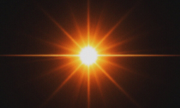 Bright orange starburst light flare on black background