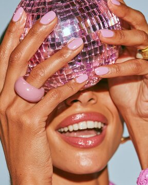 Close-up view of hands gripping a shiny disco ball for a Halloween celebration