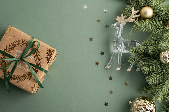 Christmas present with festive decorations and a crystal reindeer on a green background