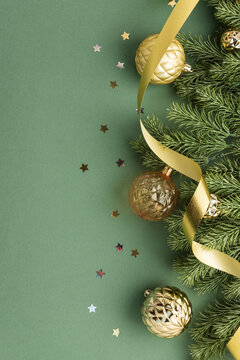 Christmas festive ornaments and pine branch with golden ribbon on green background festive greeting card element